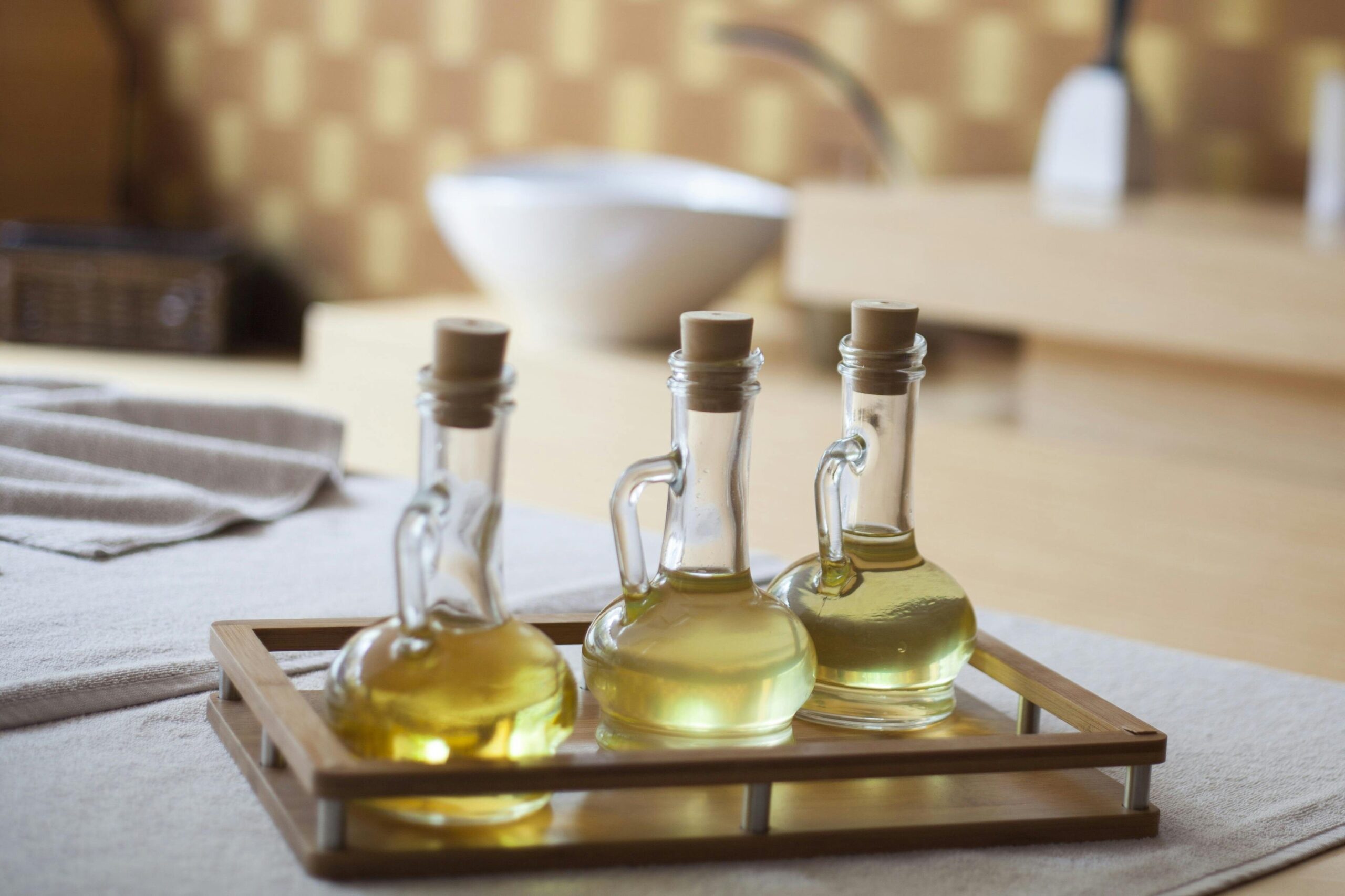 Elegant indoor spa room with natural oil bottles on a wooden tray, exuding relaxation.