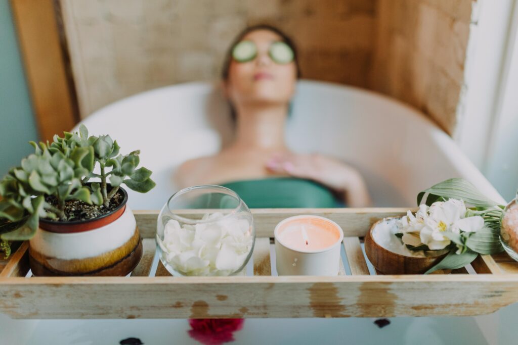 pexels-photo-6724383-6724383 Woman relaxing in a bathtub with a candle and plants, enjoying a serene spa experience.